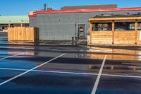 the parking lot at a small restaurant has been cleaned to clear out from the rain