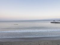 the ocean waves just below a pier on a clear day in california state of mind