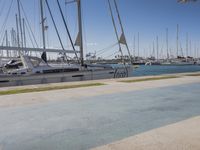 there are many small sailboats tied up at the pier and in the water on this beach