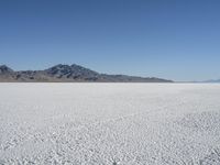 there is a snow field in the middle of nowhere on a clear day with some mountains in the distance