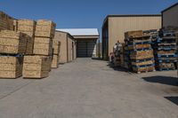 a large garage filled with lots of boxes and crates of hay stacked up to the side