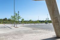 a sidewalk in the middle of a parking lot next to some tall poles and benches