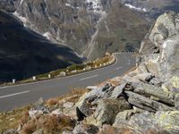 an empty mountain road running by a snowy mountain pass with a long mountain line in the distance