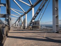 the view looking down the bridge at a bicycle rider on it's front wheel