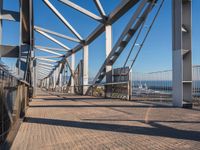 the view looking down the bridge at a bicycle rider on it's front wheel