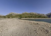 the large body of water in the desert next to a mountain range in the background