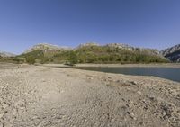 the large body of water in the desert next to a mountain range in the background