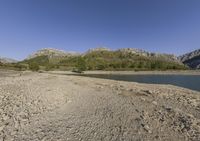 the large body of water in the desert next to a mountain range in the background