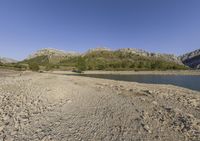 the large body of water in the desert next to a mountain range in the background