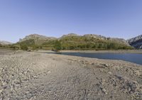 the large body of water in the desert next to a mountain range in the background