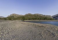 the large body of water in the desert next to a mountain range in the background