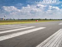 a view of the runway from the tarmac at an airport of europe that is partly cloudy