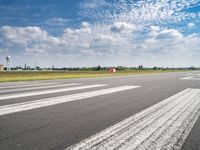 a view of the runway from the tarmac at an airport of europe that is partly cloudy