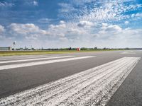 a view of the runway from the tarmac at an airport of europe that is partly cloudy