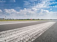 a view of the runway from the tarmac at an airport of europe that is partly cloudy