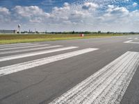 a view of the runway from the tarmac at an airport of europe that is partly cloudy