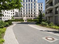 a paved street and trees in a large city area with a statue in the center of it