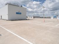 parking lot with building and parking spots against the cloudy sky with clouds in front of it