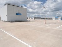 parking lot with building and parking spots against the cloudy sky with clouds in front of it