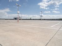 a large empty parking lot on a sunny day with bright clouds in the sky and lots of parking spaces