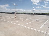 a large empty parking lot on a sunny day with bright clouds in the sky and lots of parking spaces