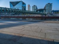 a skateboarder riding on a cement ramp next to a city street under a bridge