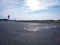 an empty runway with a sign on it and some trees in the background on top of the runway