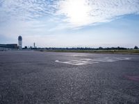 an empty runway with a sign on it and some trees in the background on top of the runway