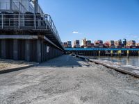 looking at an empty dock in front of a bridge that is overpassed by other buildings