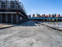 looking at an empty dock in front of a bridge that is overpassed by other buildings