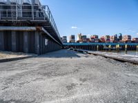 looking at an empty dock in front of a bridge that is overpassed by other buildings