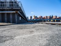 looking at an empty dock in front of a bridge that is overpassed by other buildings