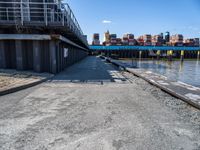 looking at an empty dock in front of a bridge that is overpassed by other buildings