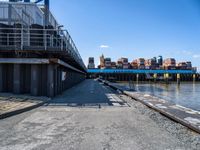 looking at an empty dock in front of a bridge that is overpassed by other buildings