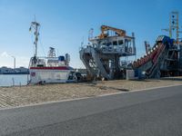 there are two large boats docked on the shore with a boat next to them to the shore