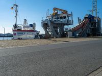 there are two large boats docked on the shore with a boat next to them to the shore