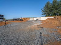 a picture of a building being built on a field near a forest in the background