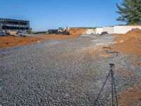 a picture of a building being built on a field near a forest in the background