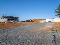 a picture of a building being built on a field near a forest in the background