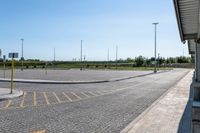 an empty parking lot in an outside city area with bright sun shining on the ground