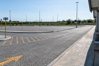 an empty parking lot in an outside city area with bright sun shining on the ground