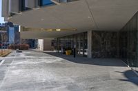 the back of a yellow fire hydrant near an entrance to a building with large glass windows