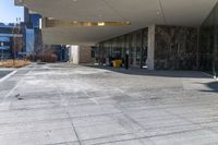 the back of a yellow fire hydrant near an entrance to a building with large glass windows