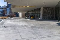 the back of a yellow fire hydrant near an entrance to a building with large glass windows