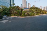 a group of pedestrians crossing the street in front of a city skyline view at sunset