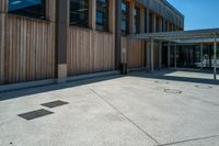 a parking spot and a lot of wooden panels on the exterior of a building in a city