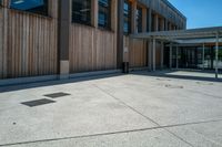 a parking spot and a lot of wooden panels on the exterior of a building in a city