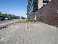 an empty parking lot sits in the middle of a city street and a large building next to it