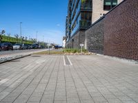 an empty parking lot sits in the middle of a city street and a large building next to it