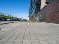 an empty parking lot sits in the middle of a city street and a large building next to it